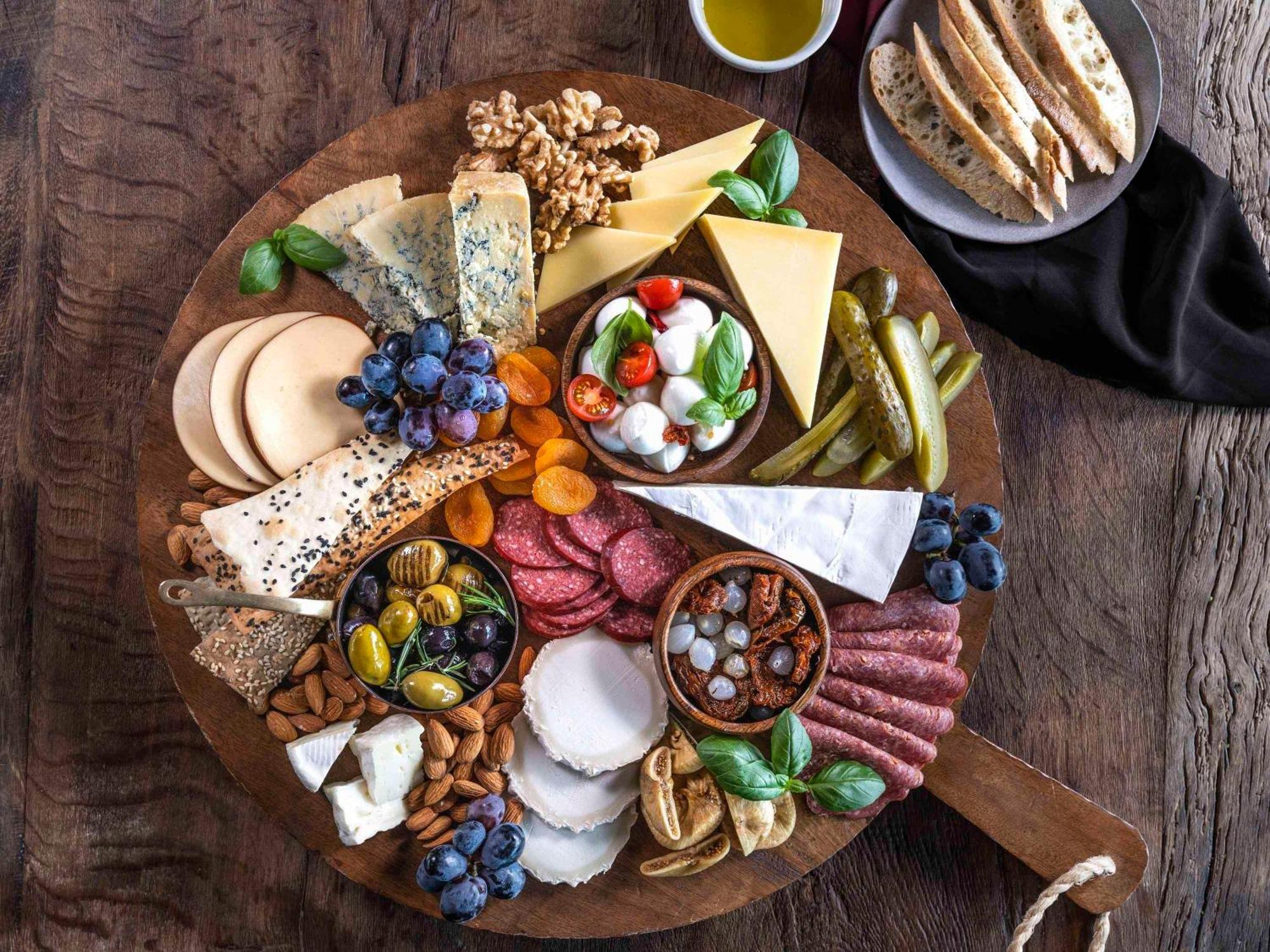 릭소스 프리미엄 두바이 Jbr 호텔 외부 사진 A cheese board with a selection of cheeses, olives, grapes, and cured meats